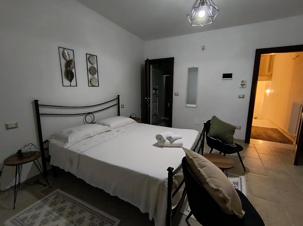 a bedroom with a large bed and two chairs at Masseria Santa Laria in Borgagne