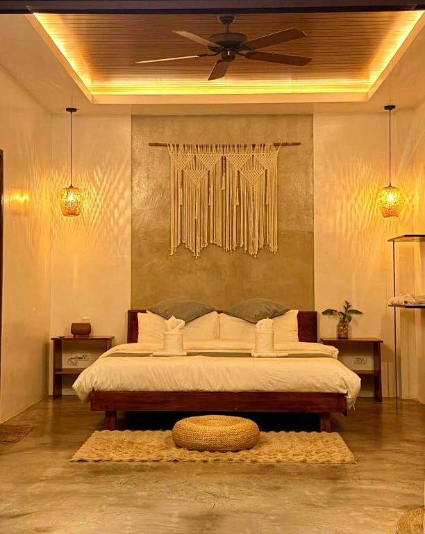 a bedroom with a bed with a ceiling fan at The Hide El Nido Villas in El Nido