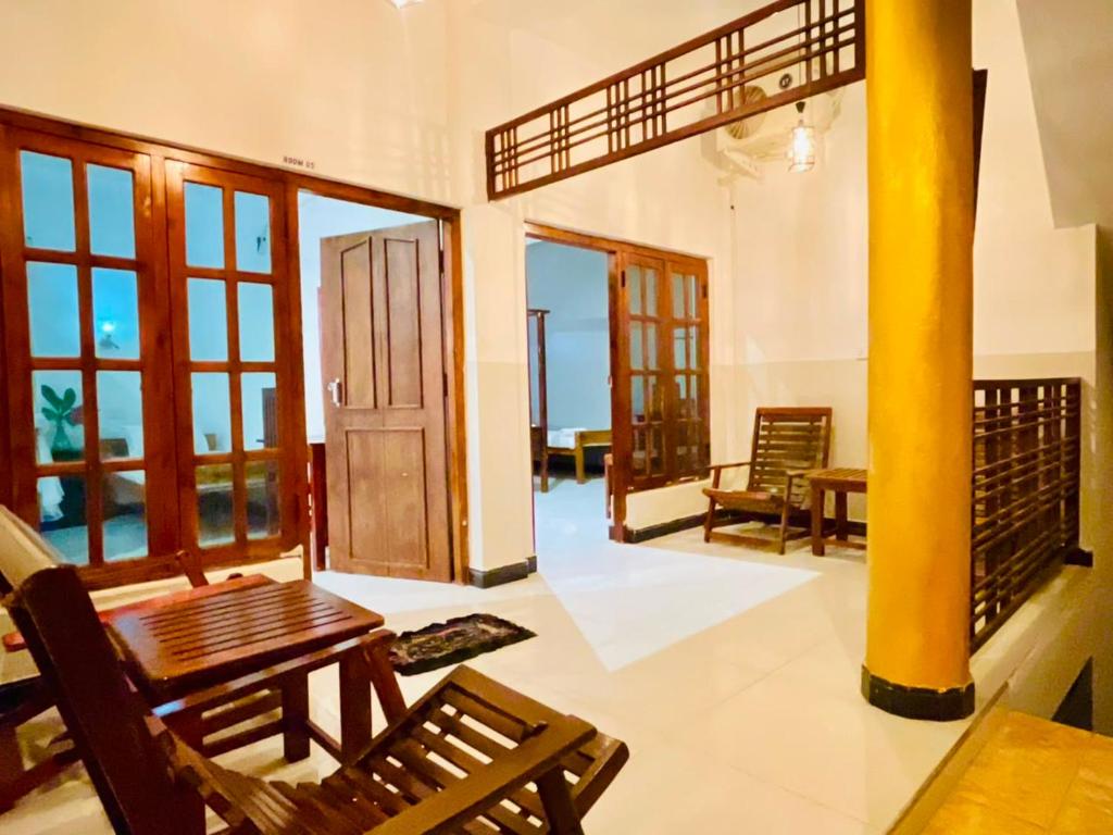 a living room with a table and chairs and windows at Soul Breeze in Arugam Bay