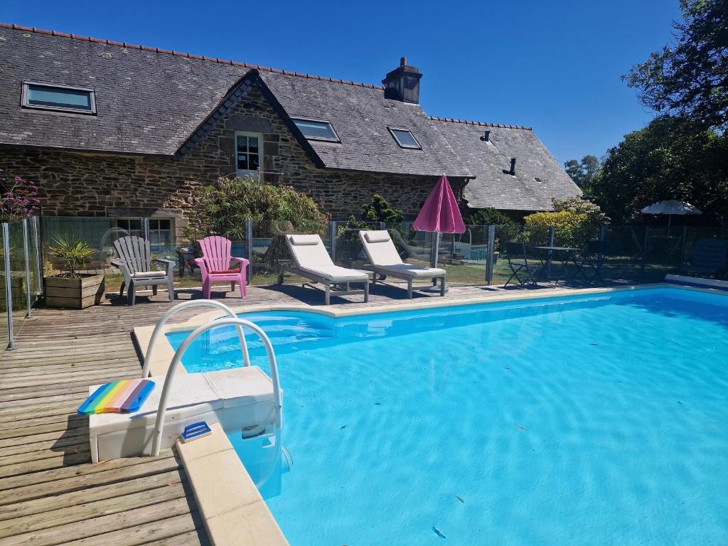 a swimming pool with chairs and a house at Longère de Nivinen in Arzano