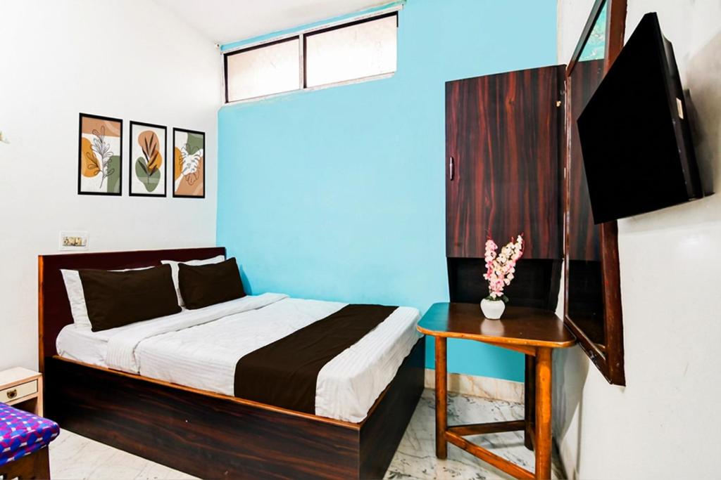 a bedroom with a bed and a table and a tv at Hotel O Akash Namostay in Jamshedpur