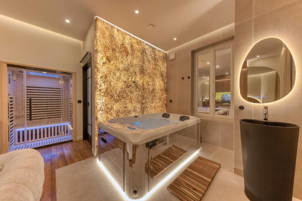 a bathroom with a sink and a mirror at Suite Prestige Spa Privatif D'exception in LʼIsle-Adam