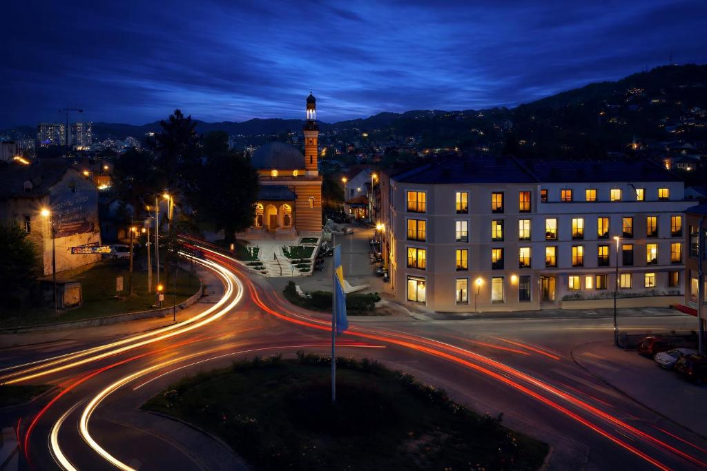 eine Stadtstraße bei Nacht mit einem Gebäude und Straßenlaternen in der Unterkunft Central Square in Tuzla