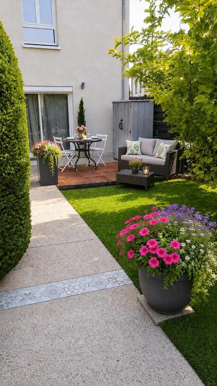 a backyard with a patio with flowers and a table at Magic Disney 5mn Peaceful Home Garden Parking in Chessy
