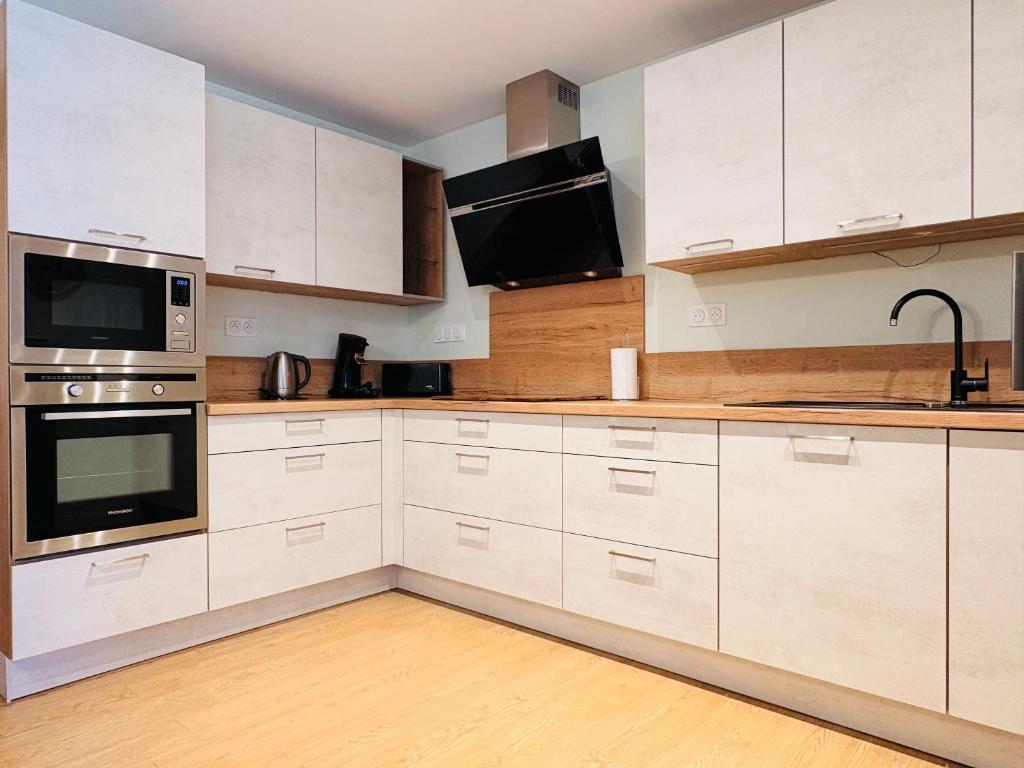 a kitchen with white cabinets and stainless steel appliances at L'Accalmie - Résidence calme, Plein centre, Plain pied in Crest
