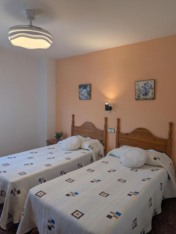 two beds in a room with white sheets at Casa Doro in Escalona