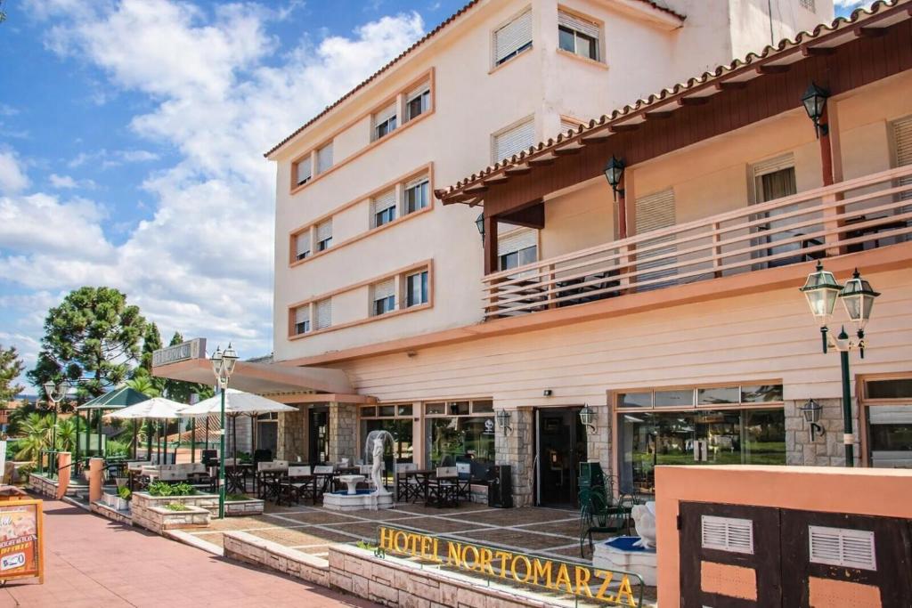 a large building with tables and chairs in front of it at Gran Hotel Nortomarza in La Falda