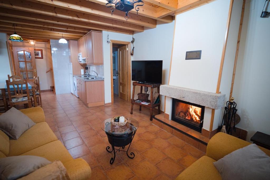 a living room with a couch and a fireplace at Casa Rural La Celestina in Navalmoro