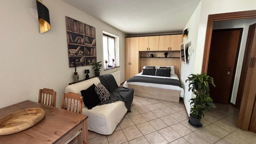 a bedroom with a bed and a couch and a table at La Casina - Centro Colere - 600mt dagli impianti in Colere