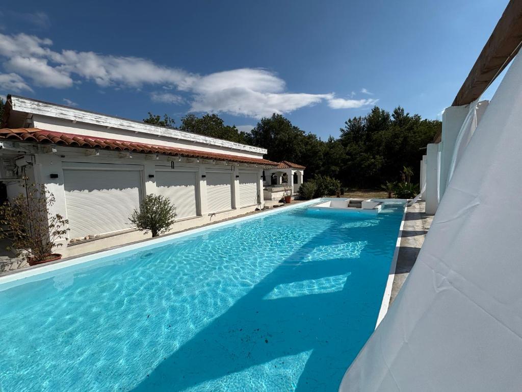 a swimming pool with blue water in a house at Borbara Apartman in Pázmándfalu