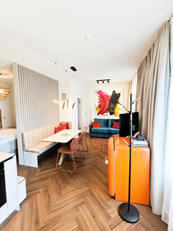 a living room with an orange suitcase and a couch at Studios zur Schmiede in Weyregg