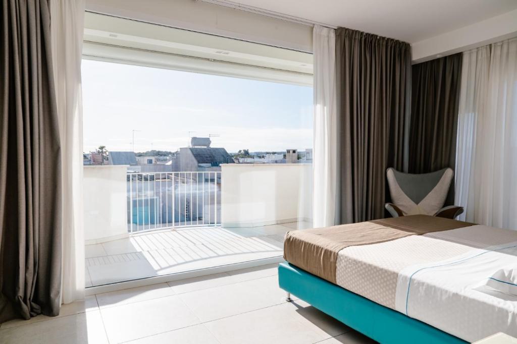 a bedroom with a bed and a large window at Hotel Cicò in Torre Santa Sabina