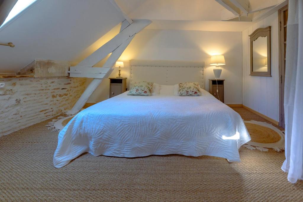 a bedroom with a white bed in a attic at Chambre duo in Sainte-Gemme-la-Plaine