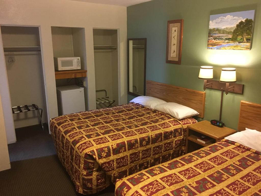 a hotel room with two beds and a microwave at The King's Inn in Sidney
