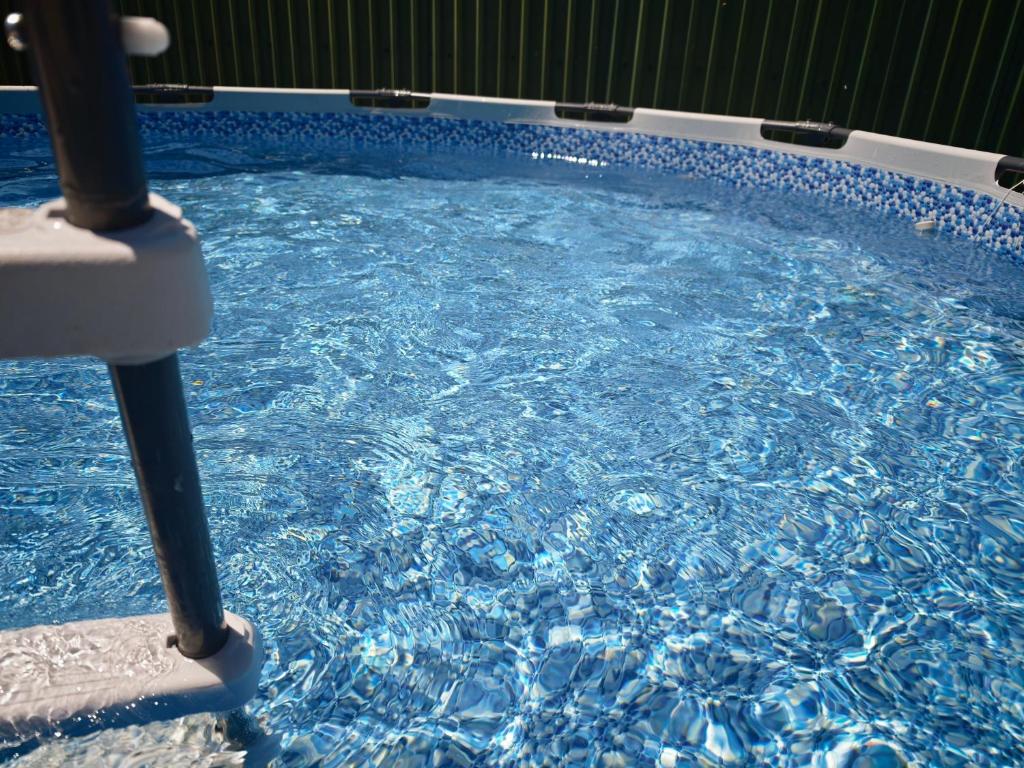 a pool of blue water with a pole in it at Bazaleti Field House in Karsimaantkari