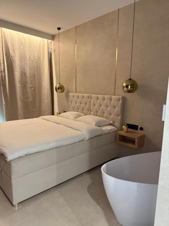 a bedroom with a bed and a bath tub at Apartament - VIDOK 110 in Olsztyn