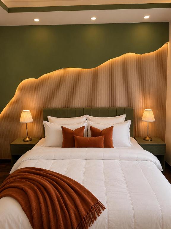 a bedroom with a large white bed with two lamps at Designer One Bedroom Apartment With Balcony & Mountain Views Opposite Centaurus Mall ISB in Islamabad