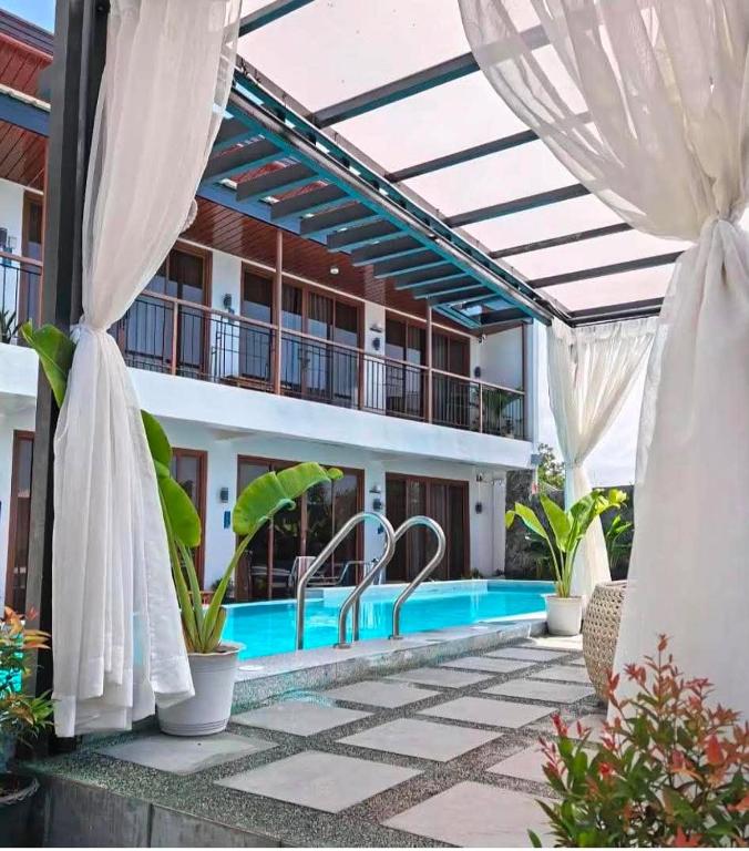 eine Terrasse mit Swimmingpool und einem Gebäude in der Unterkunft Balay Isabel in San Juan