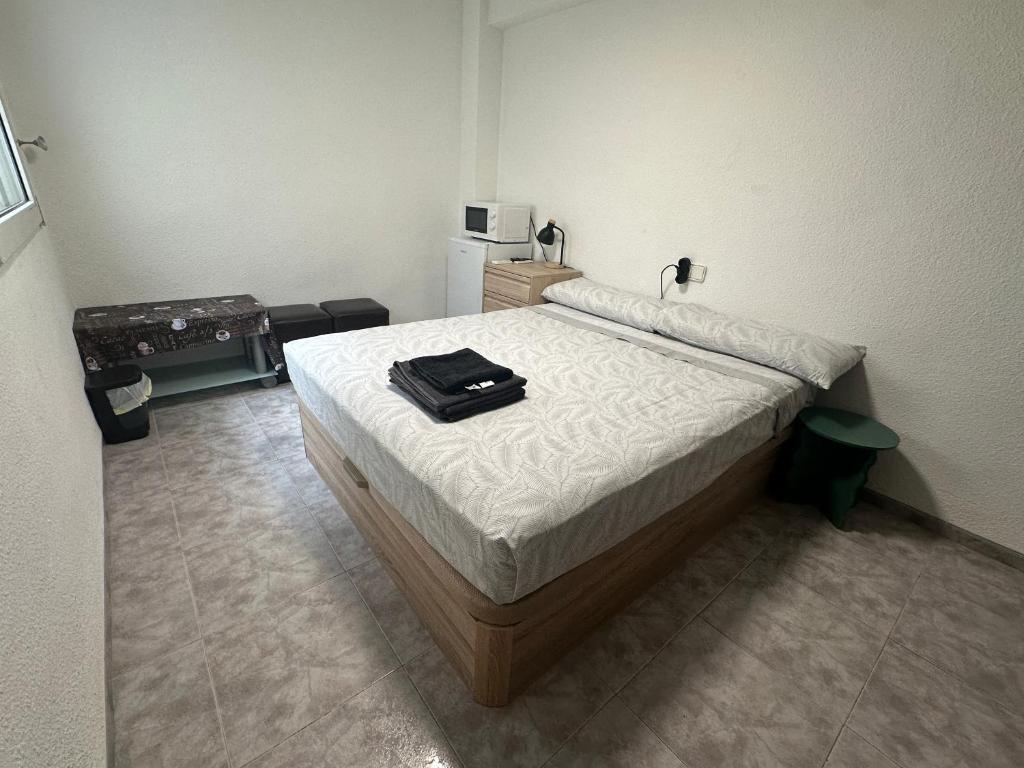 a bedroom with a bed with a black bag on it at TAJ ROOM center altea #D in Altea