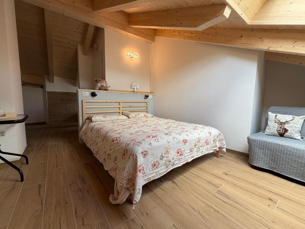 a bedroom with a bed and a chair in a room at Dalla zia Gemma in Carano