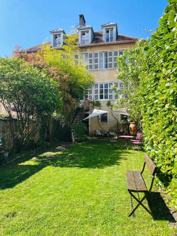 a yard with a bench in front of a house at Le Jardin De Gustave in Ornans