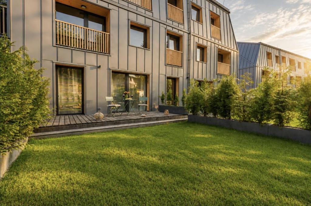 a large building with a lawn in front of it at Muhu Apartments in Velké Hamry