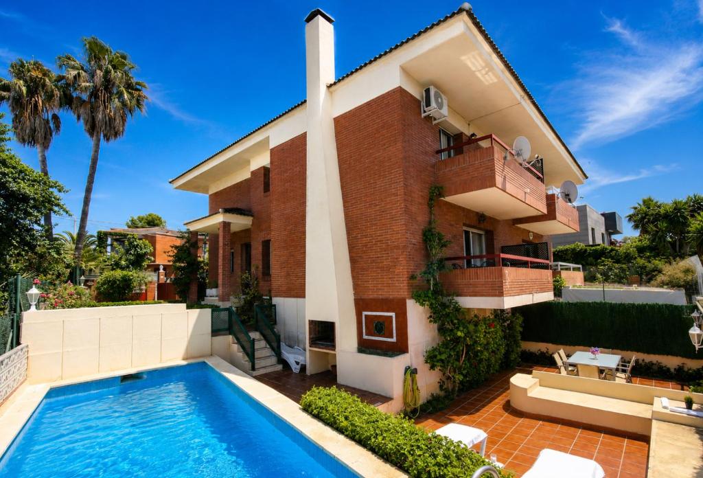 a house with a swimming pool in front of it at Villa Cococha in Salou