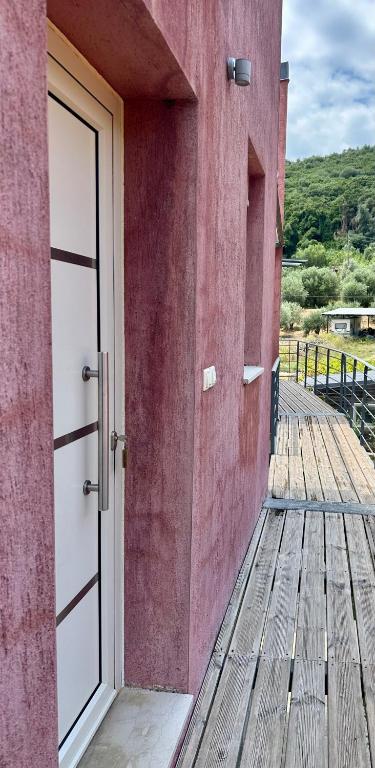 an open door on a building with a wooden deck at Glikis Ear Apartments in Gliki
