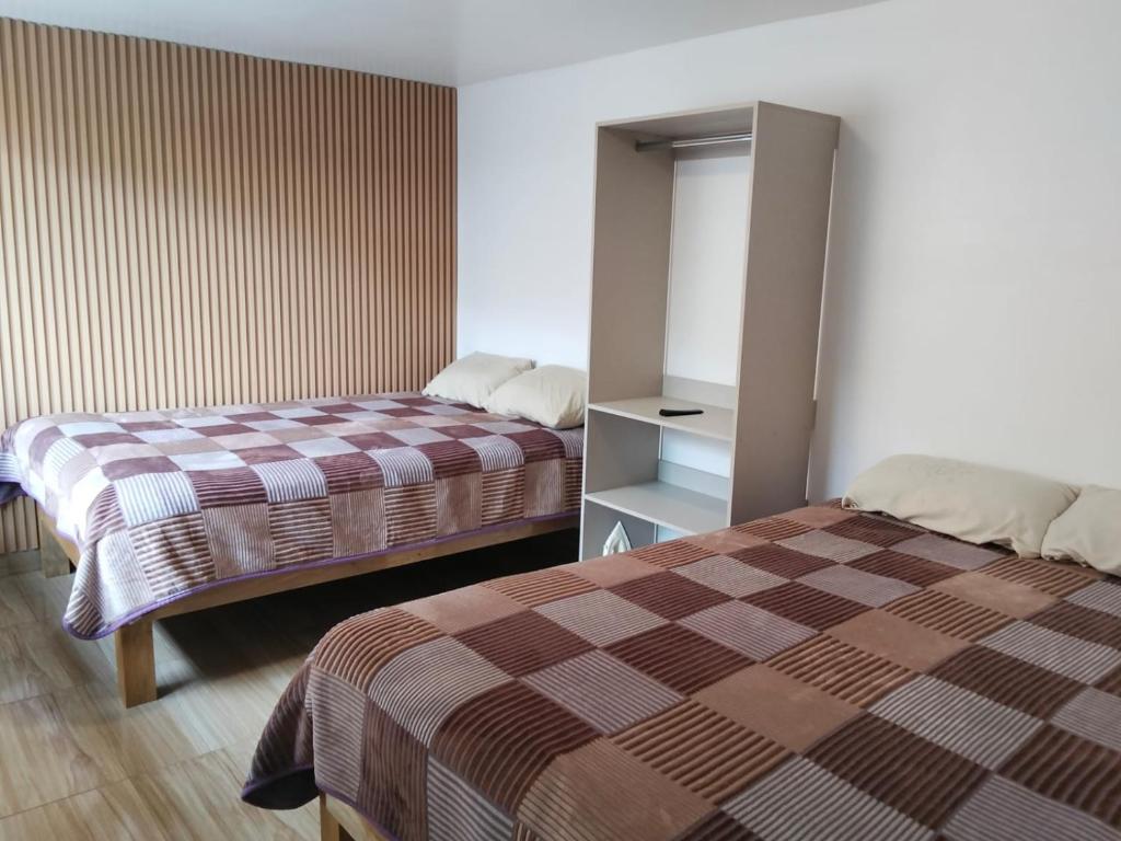 a hotel room with two beds in a room at Suite La Frontera in Tulcán