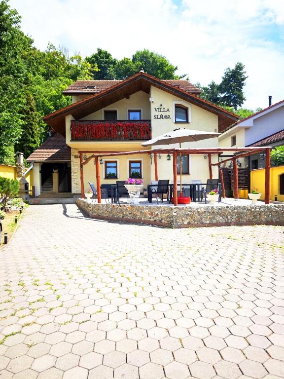 a large house with a patio with tables and umbrellas at Villa Slnava in Banka