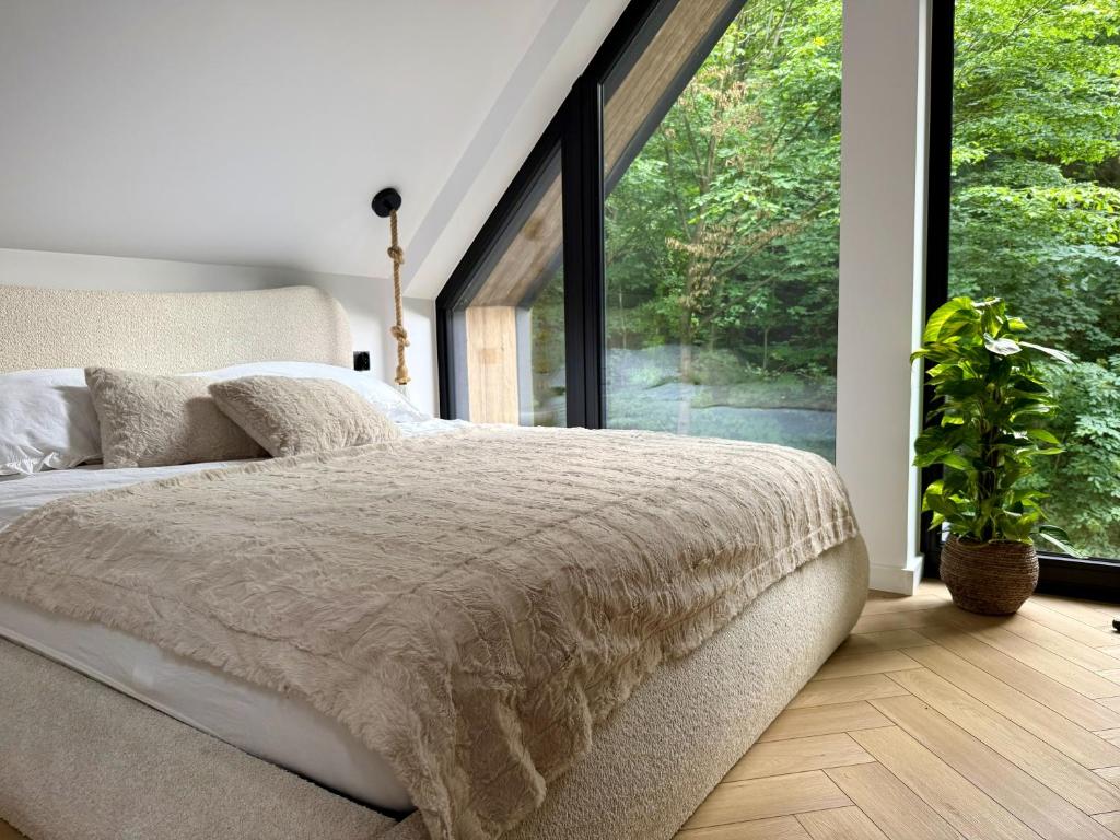 a bedroom with a bed and a large window at Leśny Azyl Rzeszów in Hermanowa