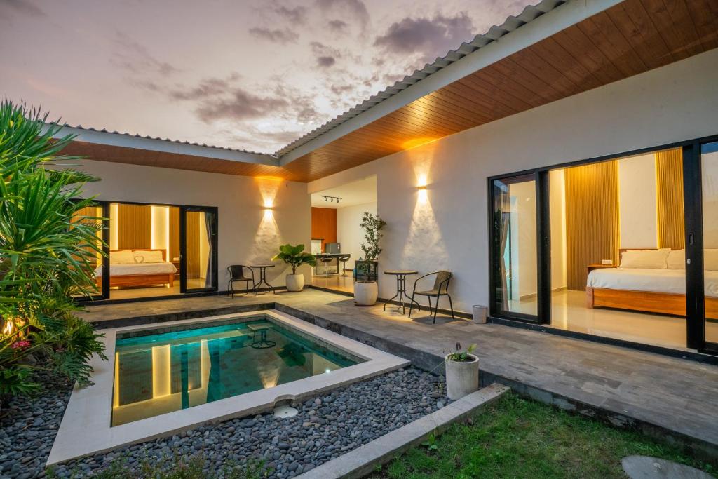 a villa with a swimming pool and a bedroom at Villa Dake Tanah Lot in Tanah Lot