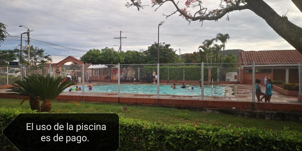 a swimming pool with people in it with a fence at Acogedor apartamento en Anapoima in Anapoima