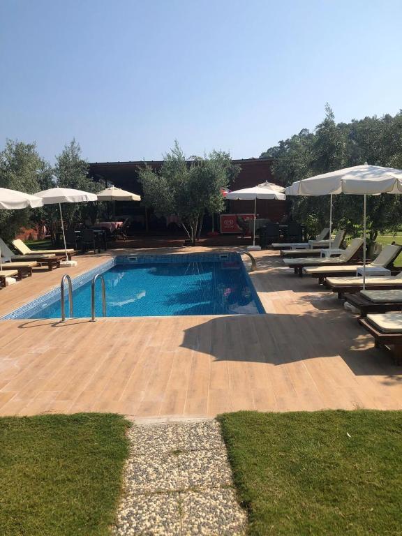 a swimming pool with lounge chairs and umbrellas at Obelix Bungalows in Fethiye