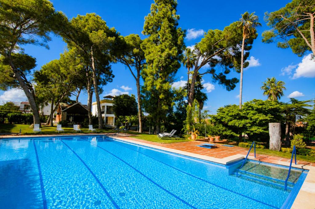 a swimming pool with trees in the background at Villa COLONIAL in Vilaseca de Solcina