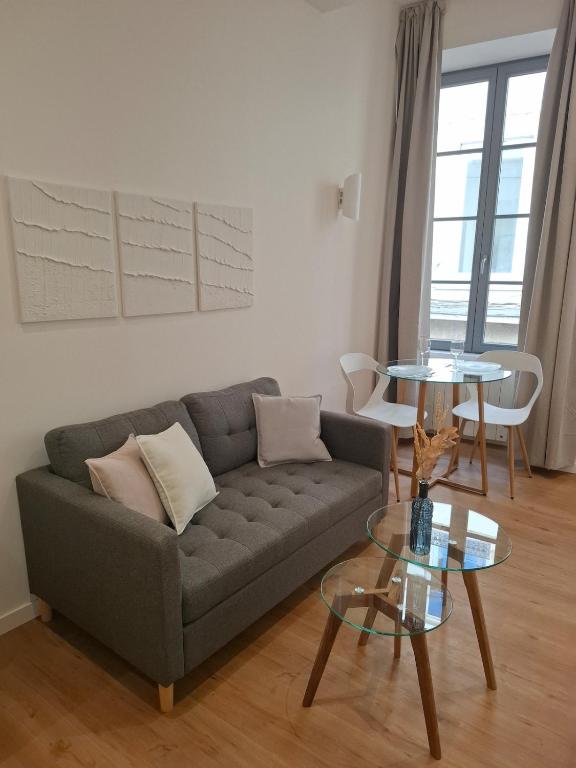 a living room with a couch and a table at Studio lumineux - 1er étage - Centre Vienne in Vienne