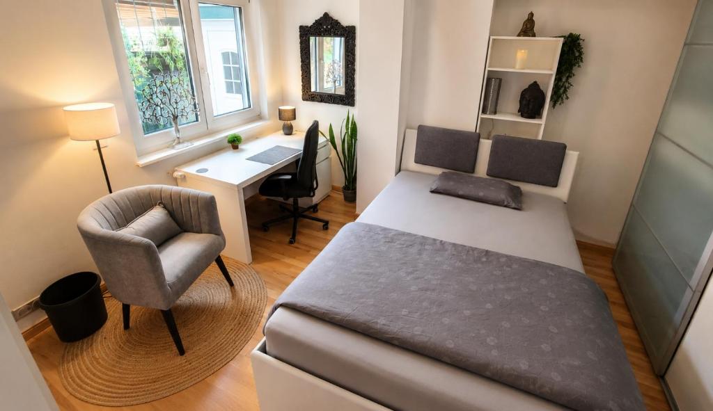 a bedroom with a bed and a desk and a chair at Gästezimmer Hönow bei Berlin in Hoppegarten