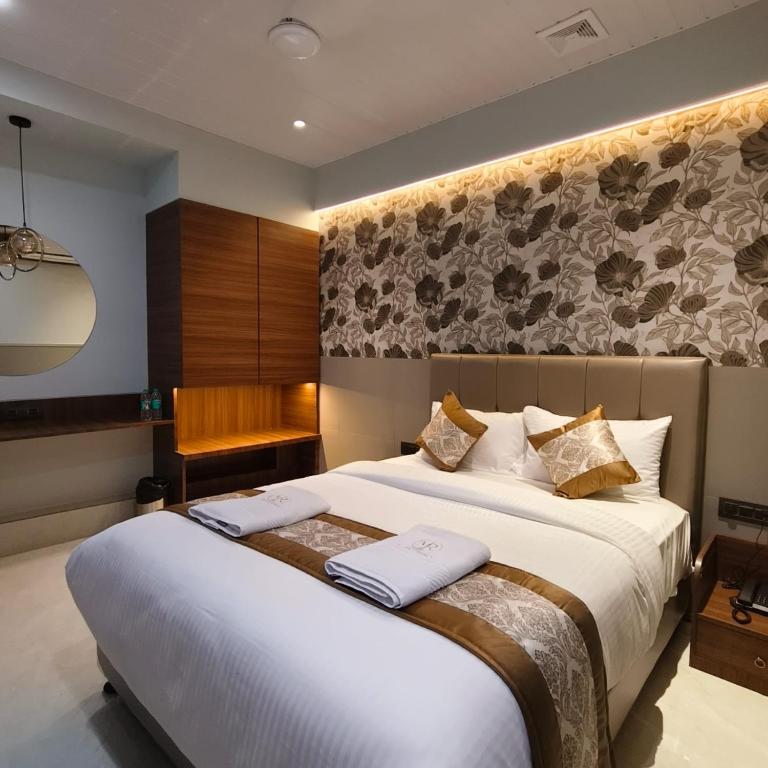 a hotel room with a bed with two towels at Mi Residency Lodging & Boarding in Thane