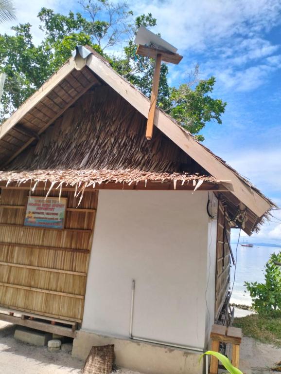 a wooden building with a white garage door at Moana Raja Ampat Homestay in Poelau Mansoear