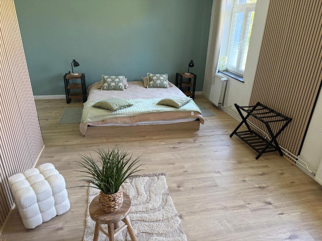a bedroom with a bed and a wooden floor at Balcony by Giorgi - Centre de Bastogne in Bastogne
