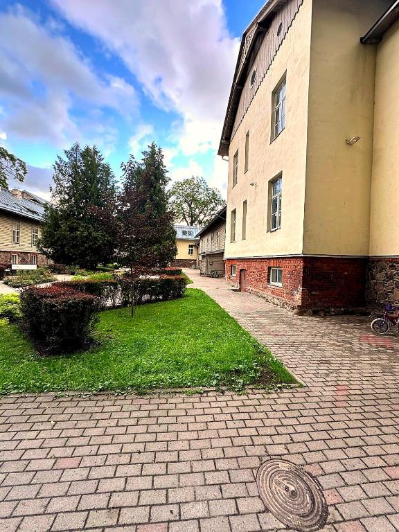 a building with a grass yard next to a building at Cathedral Apartment Tartu in Tartu