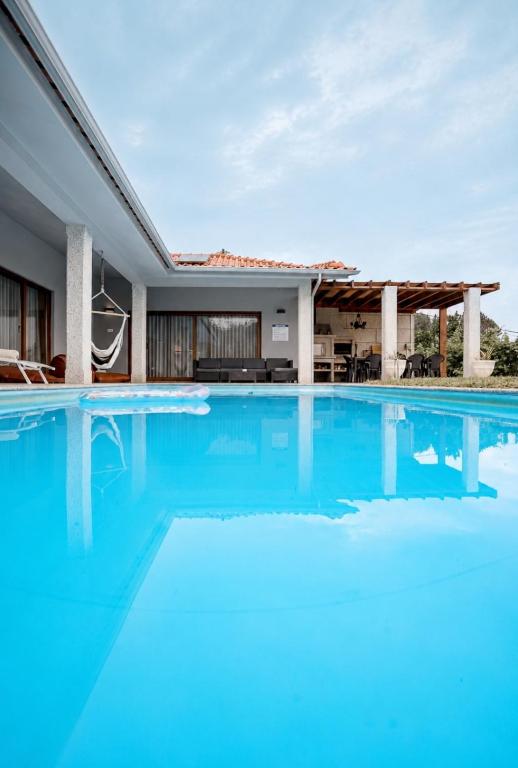 an image of a swimming pool in front of a house at Casa Fregim in Amarante