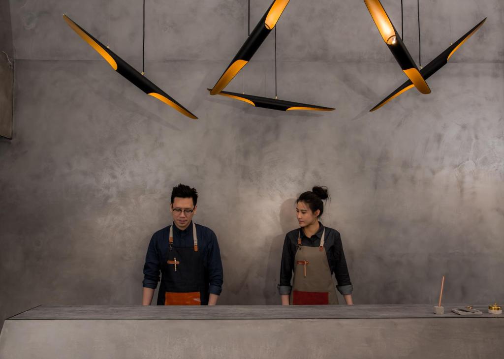 a man and a woman standing in front of a counter at Hotel Hart in Hong Kong