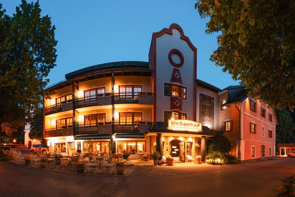 a large building with tables and chairs in front of it at Landhotel Lindenhof in Feld am See