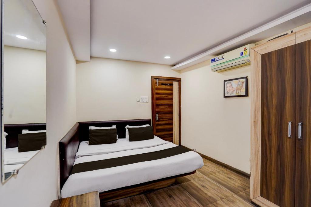 a small bedroom with a bed and a closet at Hotel O Hotel Krishna's Residency in Indore