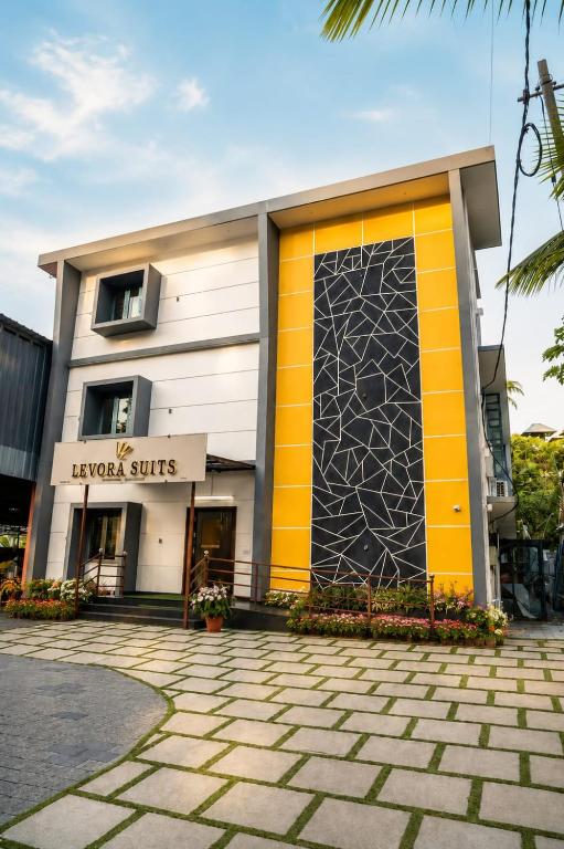 a building with a yellow and orange door at Levora Suits in Kottayam