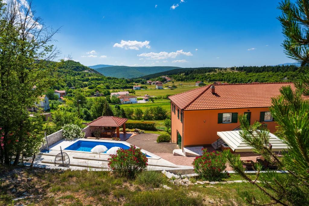 an orange house with a swimming pool in a yard at Apartment Ana with private pool in Otok