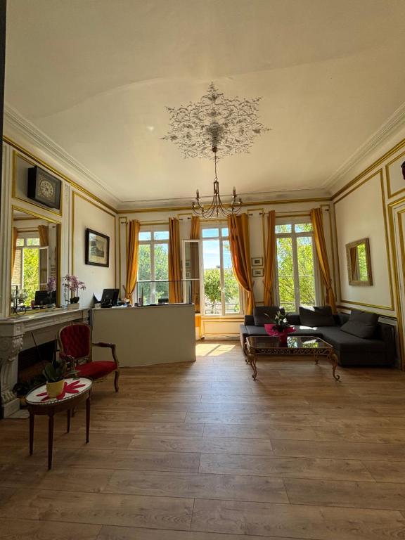 a large living room with a chandelier at Hotel du chateau blanc in Saint-Aubin-lès-Elbeuf