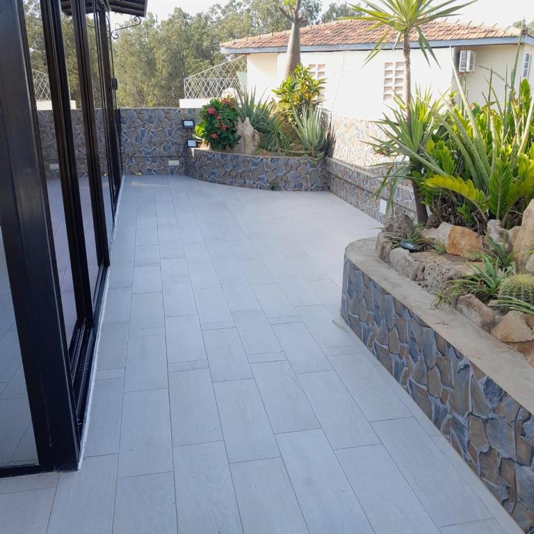 a walkway leading into a house with plants at Guest House MM in Saly Portudal