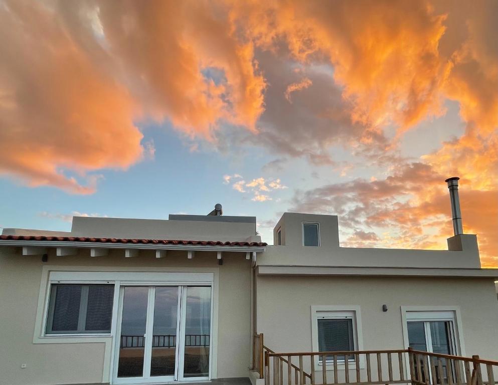 a house with a cloudy sky in the background at Oleander Villa in Rafina